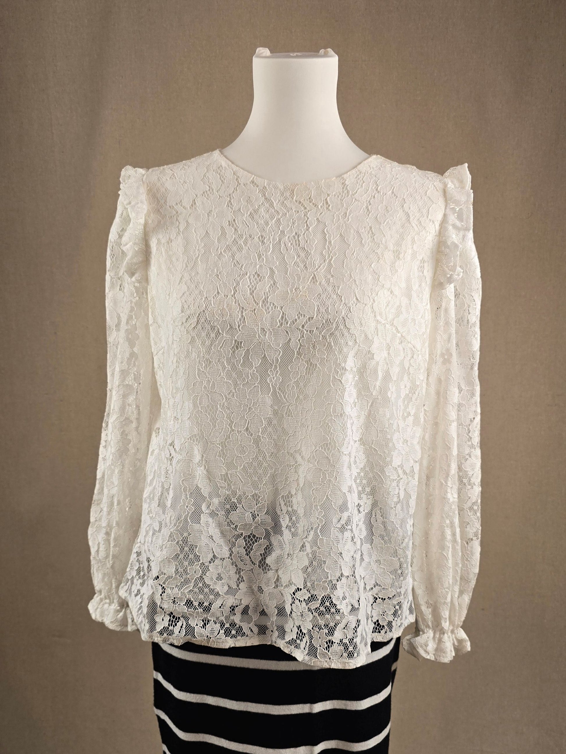 Cremeweißes Spitzenshirt mit Raffärmeln und floralem Muster, Vorderansicht auf Schneiderbüste.