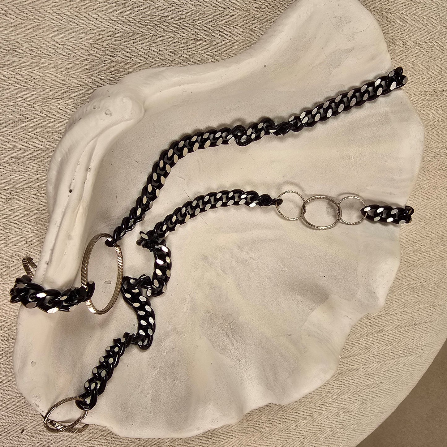 Halskette „Chain Reaction“ mit silberfarbenen Gliedern und schwarzem Stoffband mit weißen Punkten – auffälliger, flexibler Materialmix