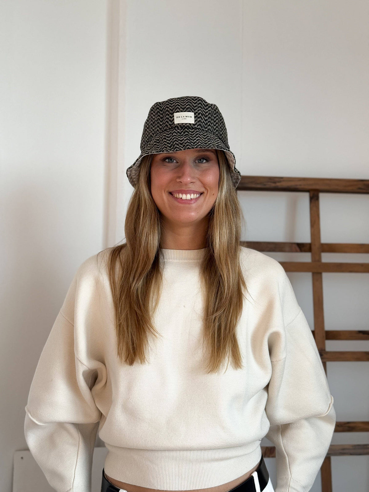 Model mit De La Mur Dana Bucket Hat aus Jacquard mit Zickzackmuster in Beige und Schwarz