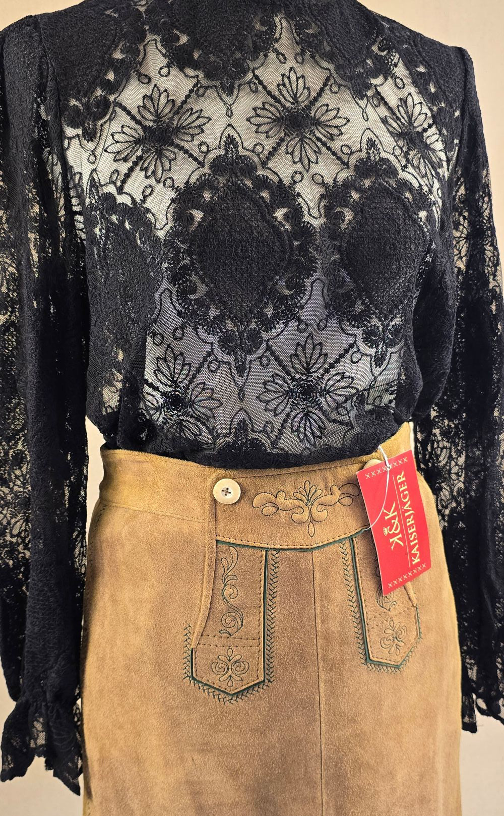 Schwarze Spitzenbluse mit Stehkragen, vorne getragen zum Echtleder-Trachtenrock, elegante Kombination.