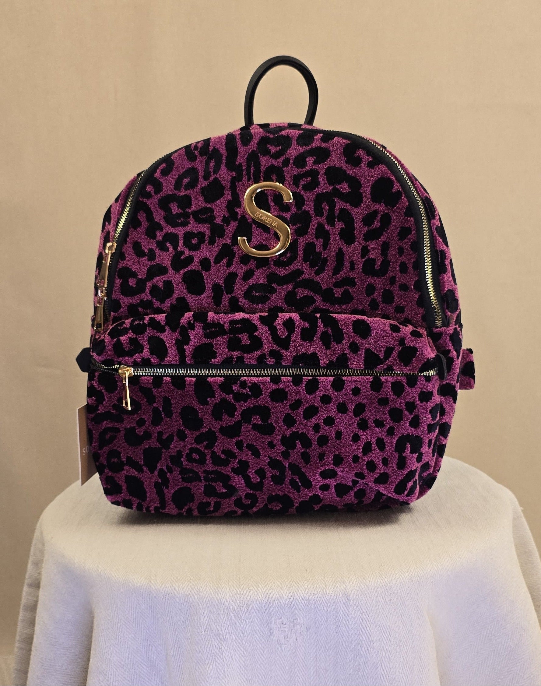 Sorena Backpack in Magenta mit schwarzem Leopardenmuster, goldenem S-Logo und Frontfach mit Reißverschluss.