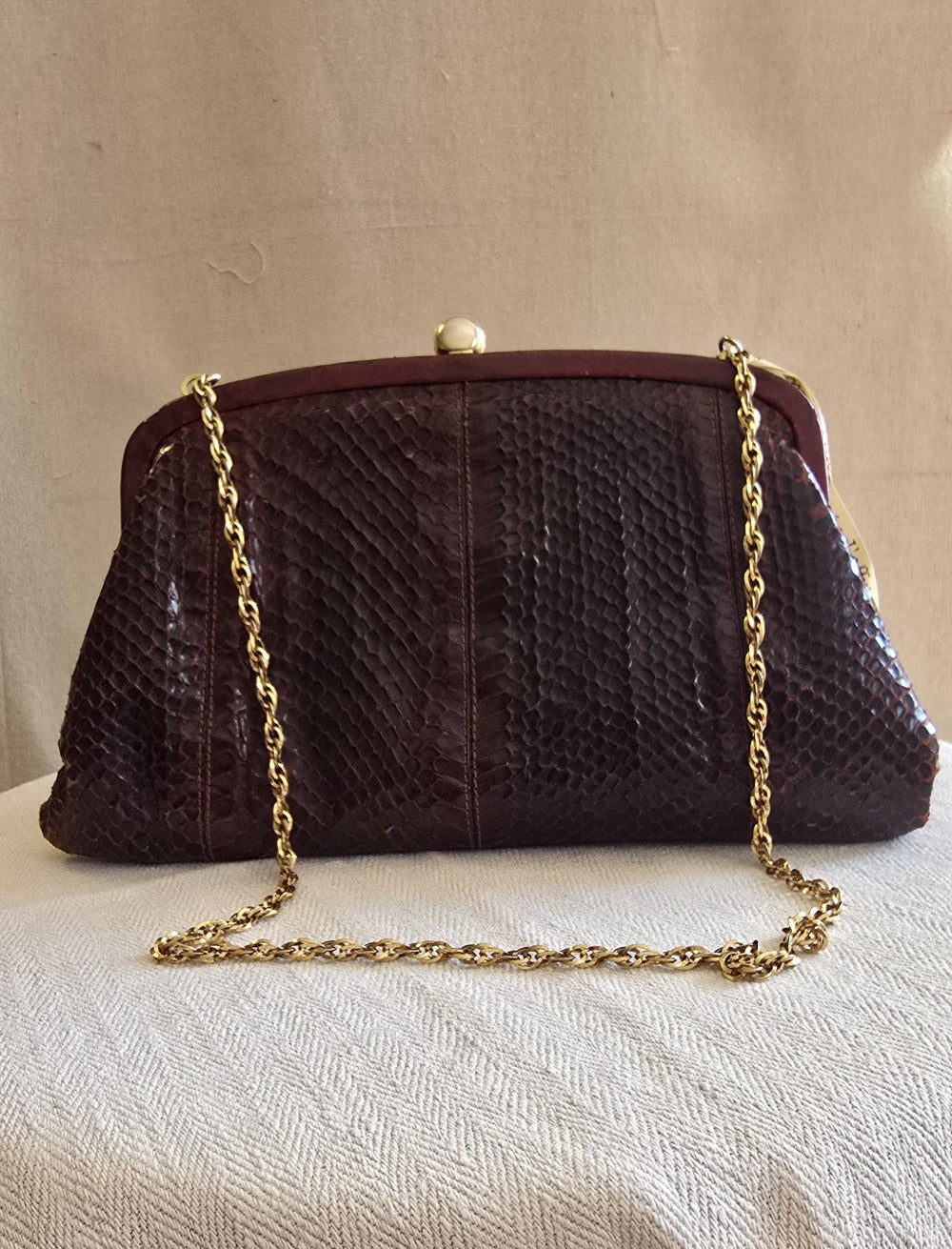 Vintage-Klapptasche in Bordeaux mit goldener Gliederkette – Vorderansicht auf hellem Leinentuch