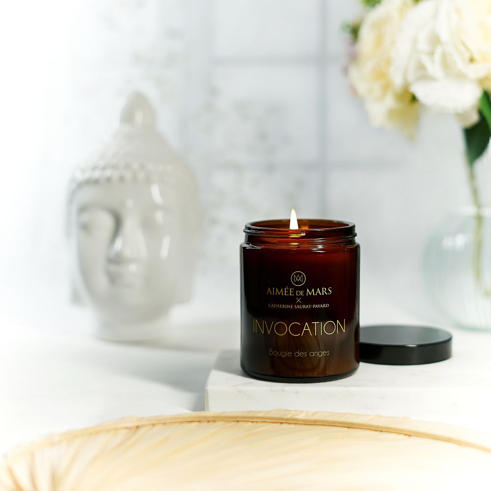 Aimée de Mars Invocation 150 g Duftkerze mit weißer Buddha-Figur im Hintergrund – natürliche Kerze mit Freesie, Jasmin und Myrrhe