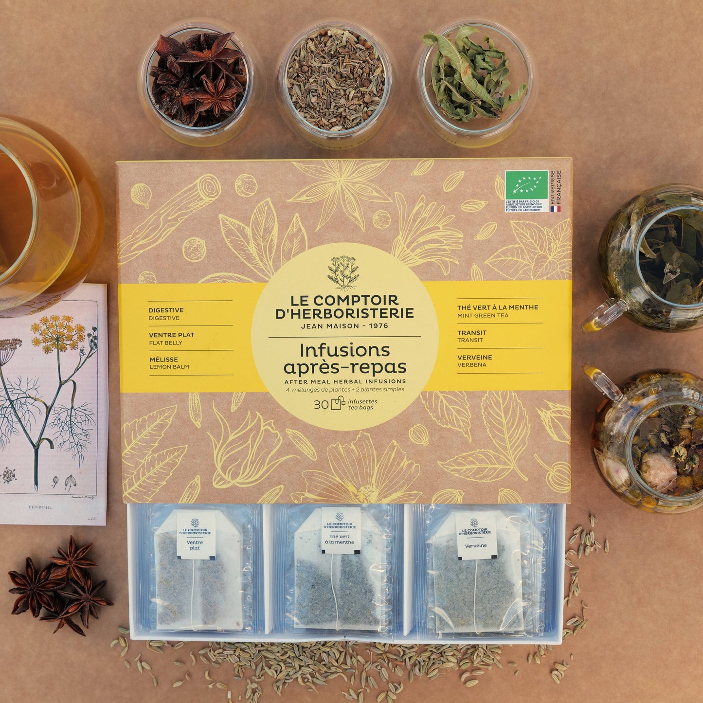 Bio-Teebox Nach dem Essen von Le Comptoir d’Herboristerie mit 6 Sorten und 30 Teebeuteln, arrangiert mit Tasse, Kräutern und Gewürzen.