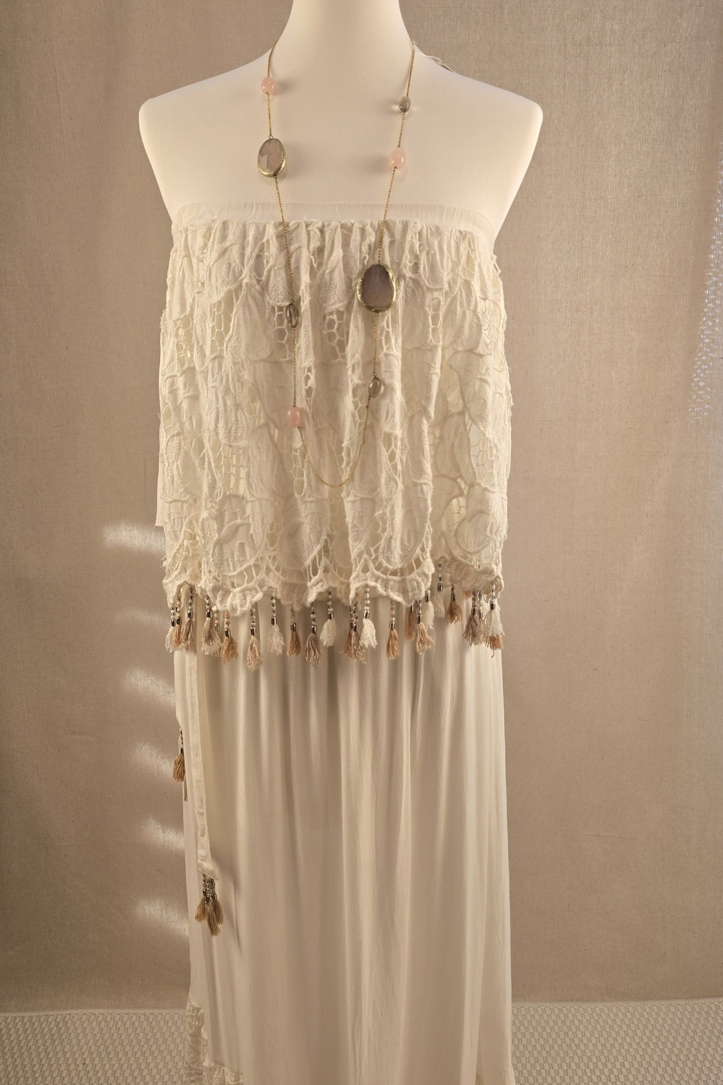Lange Halskette mit Rosenquarz und Rauchquarz kombiniert mit cremefarbenem Boho-Kleid mit Häkelspitze – romantischer Sommerlook mit Natursteinen und fließender Silhouette