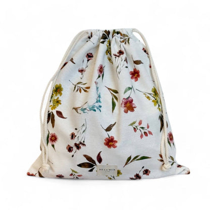 Snackbeutel Haley von De La Mur mit farbenfrohem Blumenmuster auf naturweißem Hintergrund vor weißem Hintergrund.