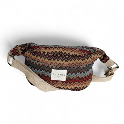 Crossbody-Gürteltasche Monte von De La Mur mit mehrfarbigem Zickzackmuster vor weißem Hintergrund