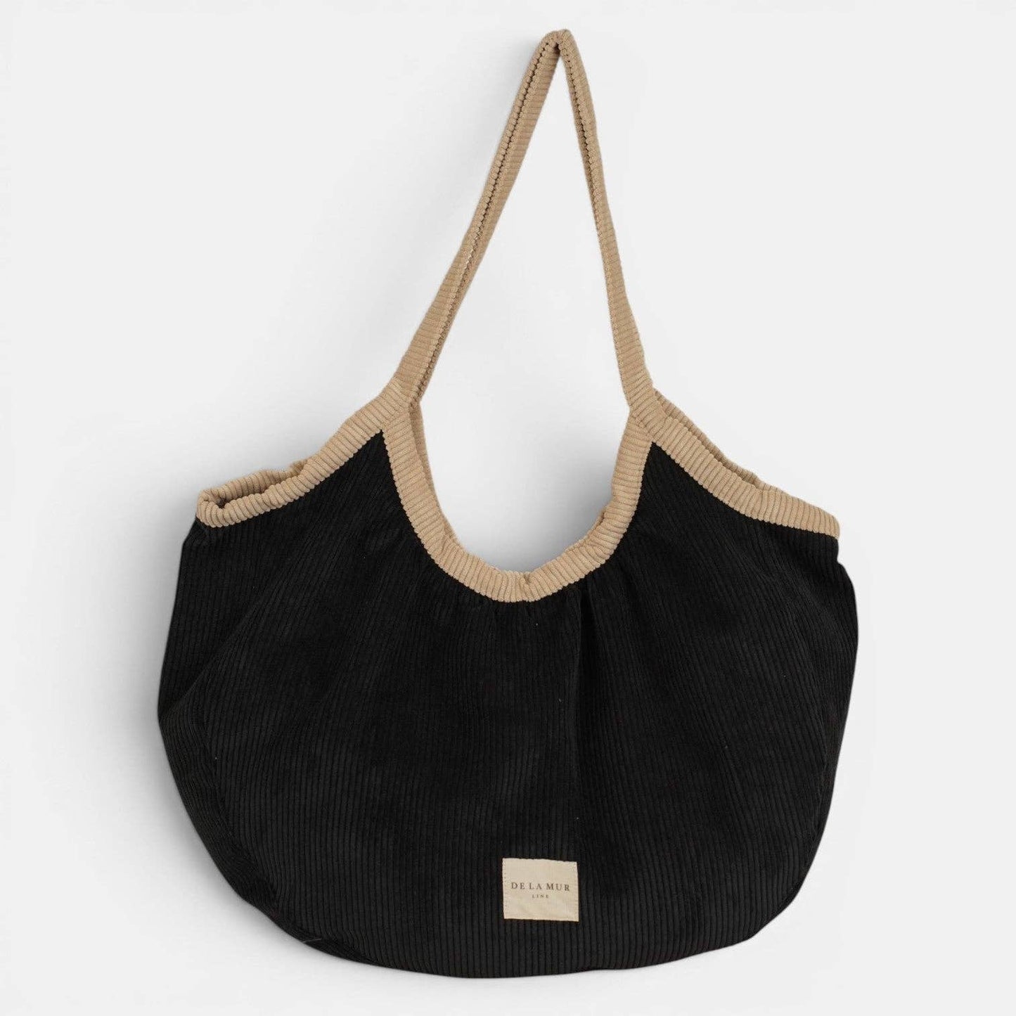 Schwarzer De La Mur Nit Cord Shopper mit breiter beiger Paspel, hellen Schulterhenkeln und Reißverschluss.