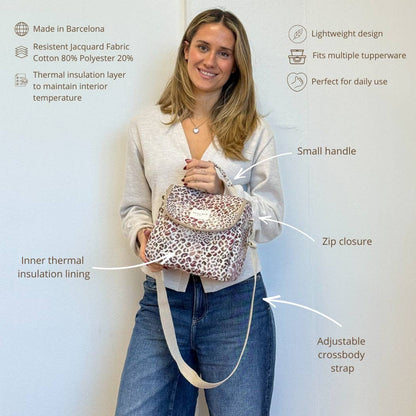Frau trägt die isolierte Lunchtasche Talco von De La Mur mit rosa-lilafarbenem Leopardenmuster.