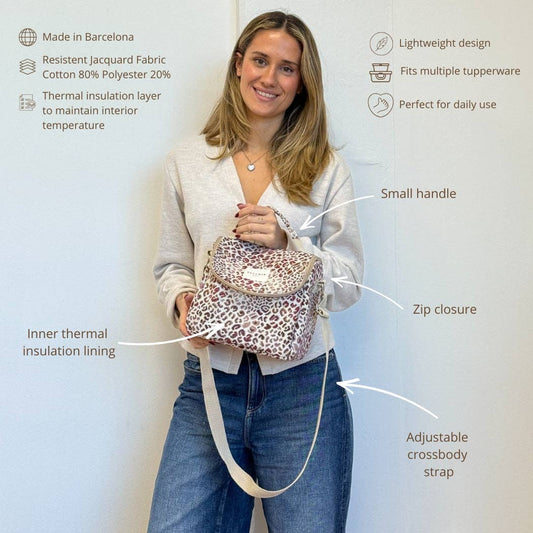 Frau trägt die isolierte Lunchtasche Talco von De La Mur mit rosa-lilafarbenem Leopardenmuster.