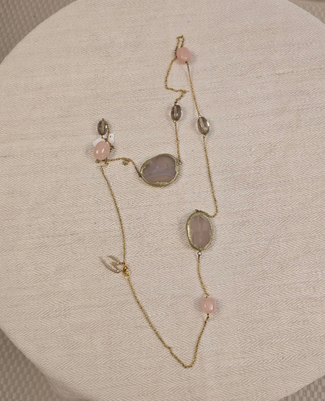 Lange Halskette mit Rosenquarz, Rauchquarz und großen Natursteinen – dekorativ arrangiert auf naturfarbenem Leinentuch, ideal für Boho-Accessoires mit natürlichem Flair