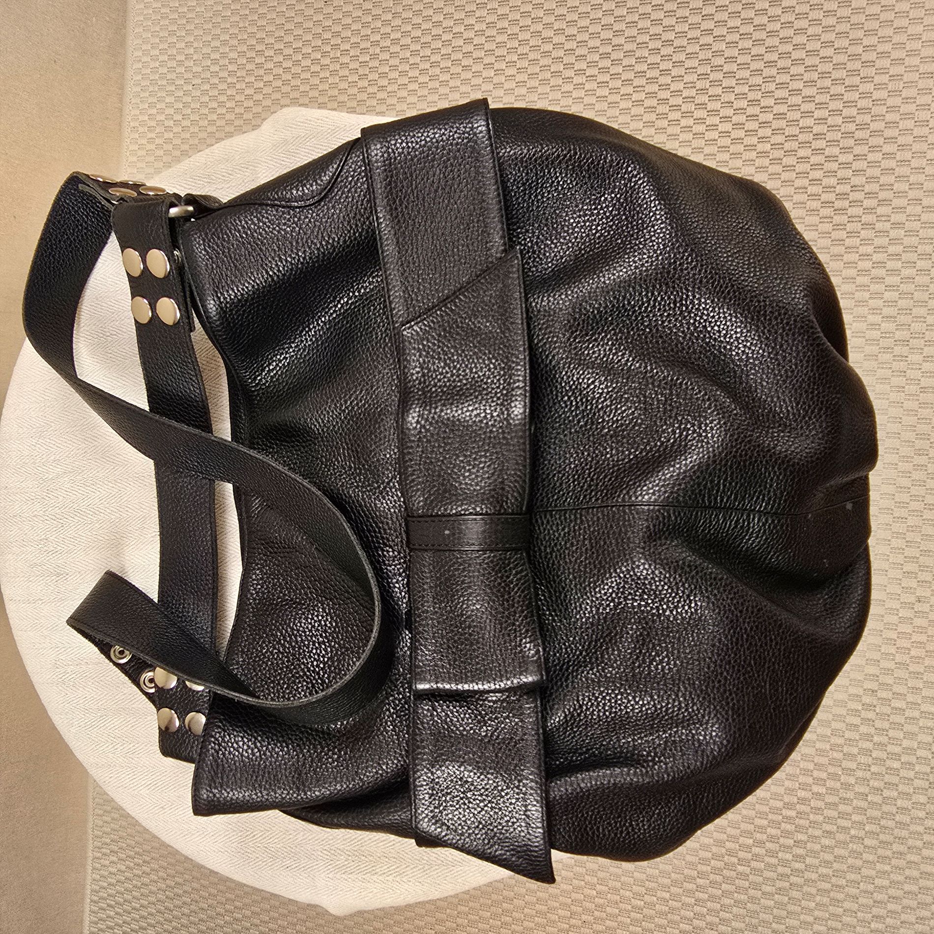 Schwarzer Ledershopper mit markanter Schleife und silbernen Nieten – edles Replikat im Stil von Armani, aus weichem, schwerem Leder, stilvoll inszeniert auf rundem, hellen Untergrund.