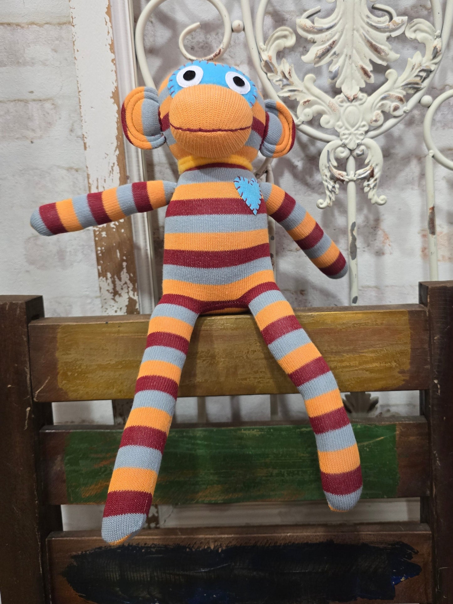 Handgemachter HickUps Sockenaffe Midi in Orange, Burgund und Grau auf einem Holzstuhl