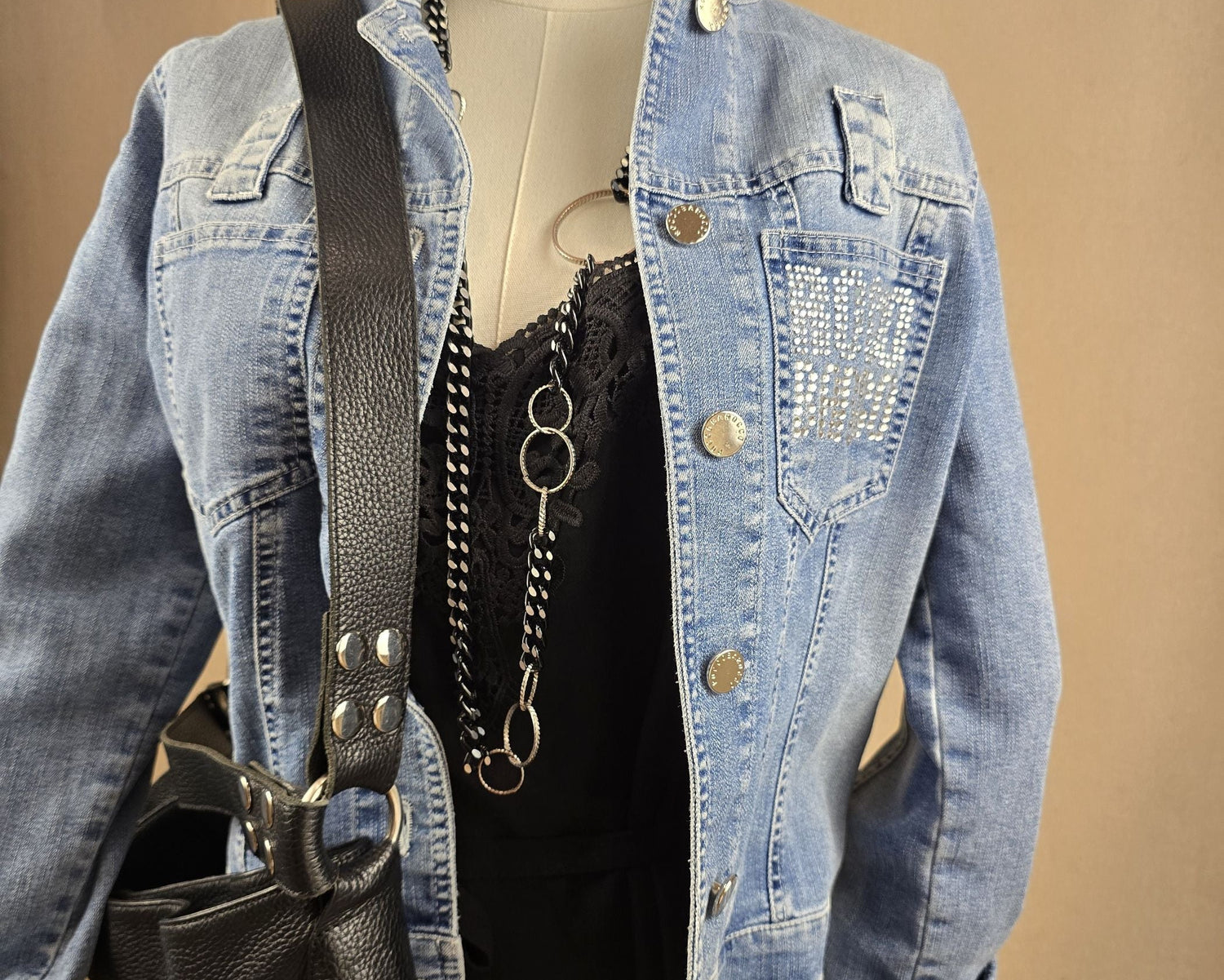 Vintage-Jeansjacke von Roccobarocco in Mittelblau mit silbernen Knöpfen und glitzerndem Logo-Schriftzug – Look der Woche bei Mediterrana

